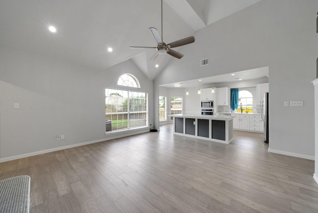 412 Belmont Ct, Lewisville, TX 75067 - unfurnished living room featuring a ceiling fan, light wood-style flooring, recessed lighting, healthy amount of natural light, and high vaulted ceiling