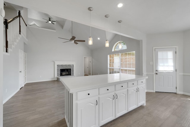 412 Belmont Ct, Lewisville, TX 75067 - kitchen featuring ceiling fan, white cabinets, a stone fireplace, plenty of natural light, and recessed lighting