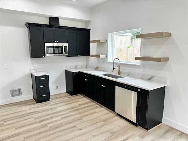 2328 Wavell St, Houston, TX 77088 - kitchen featuring stainless steel appliances, open shelves, dark cabinets, light wood-style flooring, and light stone counters