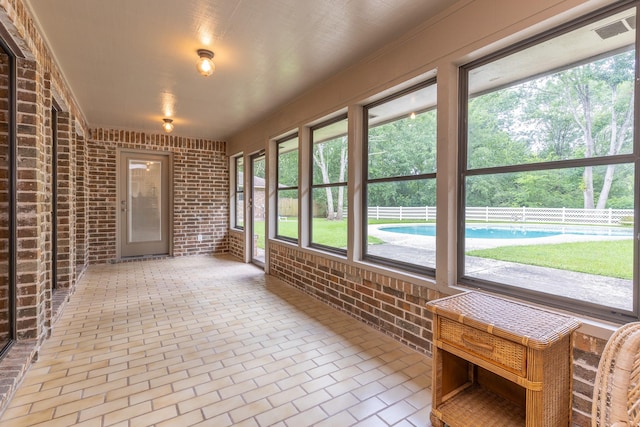 1211 Tall Pines Dr, Friendswood, TX 77546 - unfurnished sunroom with brick wall, brick flooring, and plenty of natural light