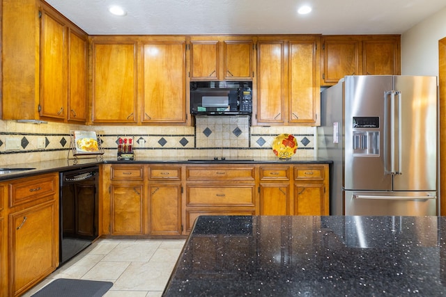 1211 Tall Pines Dr, Friendswood, TX 77546 - kitchen with black appliances, brown cabinetry, dark stone counters, tasteful backsplash, and recessed lighting