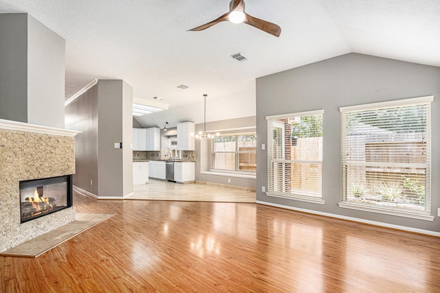 3311 Baden Oaks Ct, Katy, TX 77494 - unfurnished living room with lofted ceiling, ceiling fan, light wood-style flooring, and a tile fireplace