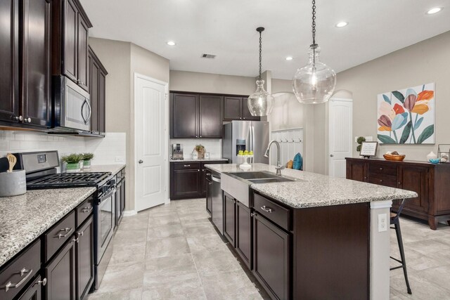 29522 Westhope Dr, Spring, TX 77386 - kitchen with appliances with stainless steel finishes, tasteful backsplash, a center island with sink, recessed lighting, and a breakfast bar area