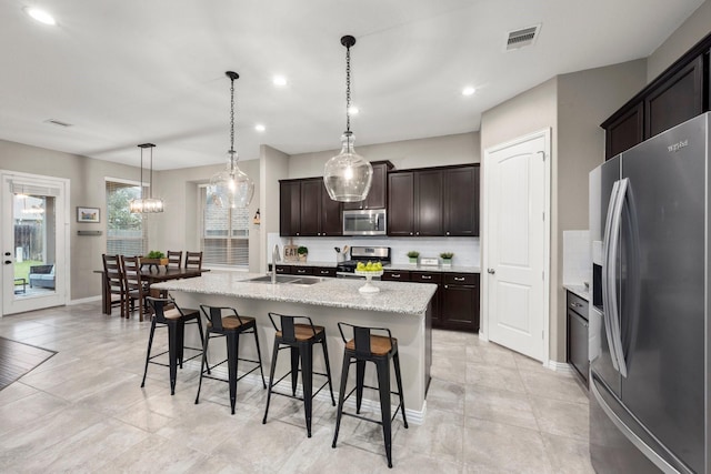29522 Westhope Dr, Spring, TX 77386 - kitchen with stainless steel appliances, a breakfast bar area, backsplash, recessed lighting, and a center island with sink