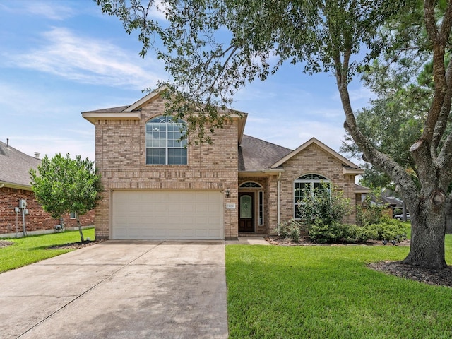 3139 Prairiestone Trail Ln, Katy, TX 77450 - traditional-style house featuring driveway, a front yard, an attached garage, and brick siding