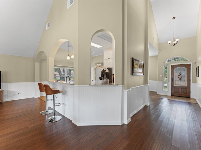 3139 Prairiestone Trail Ln, Katy, TX 77450 - entryway featuring high vaulted ceiling, wainscoting, dark wood-style floors, arched walkways, and a chandelier