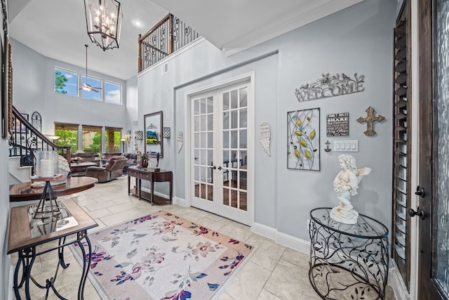 207 Fox Squirrel Ct, Pinehurst, TX 77362 - tiled entrance foyer with french doors, a chandelier, stairway, a high ceiling, and crown molding