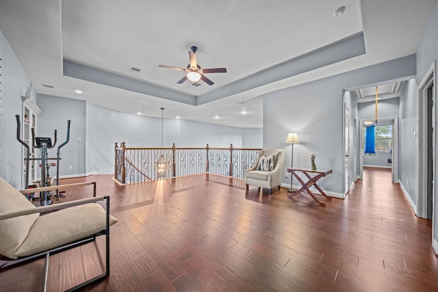 207 Fox Squirrel Ct, Pinehurst, TX 77362 - living area featuring attic access, a tray ceiling, a ceiling fan, an upstairs landing, and wood finished floors
