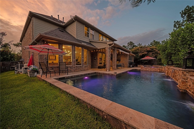 207 Fox Squirrel Ct, Pinehurst, TX 77362 - back of property at dusk with a patio, brick siding, and a pool with connected hot tub