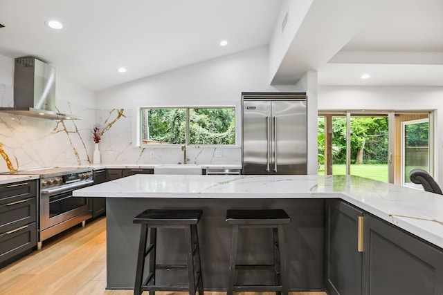 4543 Warm Springs Rd, Houston, TX 77035 - kitchen featuring stainless steel appliances, wall chimney range hood, light stone countertops, backsplash, and recessed lighting