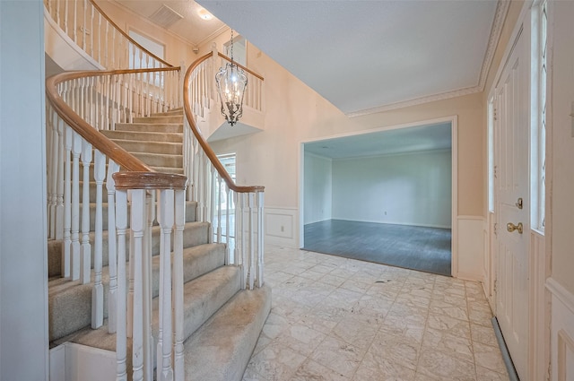 5318 Foresthaven Dr, Houston, TX 77066 - stairs featuring wainscoting, ornamental molding, and a decorative wall