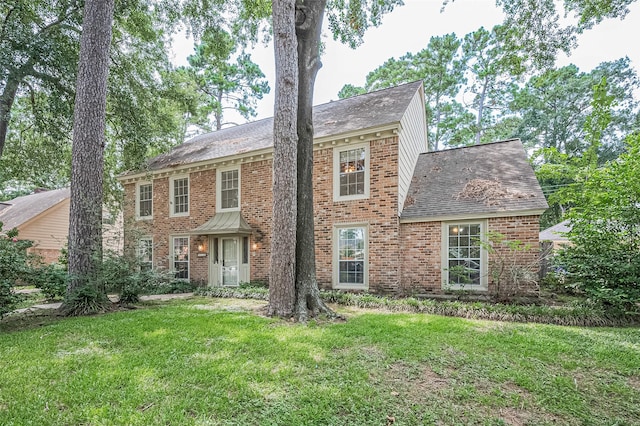 5318 Foresthaven Dr, Houston, TX 77066 - georgian-style home with a front yard, roof with shingles, and brick siding