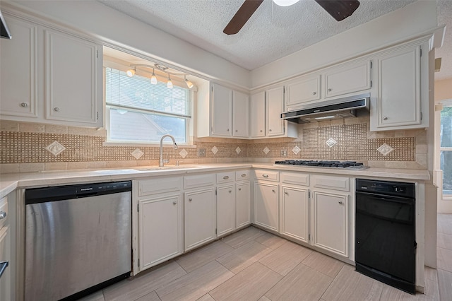 5318 Foresthaven Dr, Houston, TX 77066 - kitchen with stainless steel dishwasher, under cabinet range hood, gas stovetop, ceiling fan, and light countertops