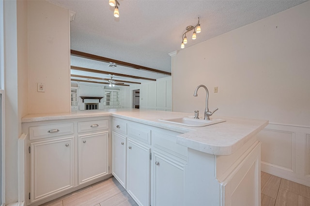 5318 Foresthaven Dr, Houston, TX 77066 - kitchen featuring ceiling fan, beamed ceiling, light countertops, a peninsula, and white cabinets
