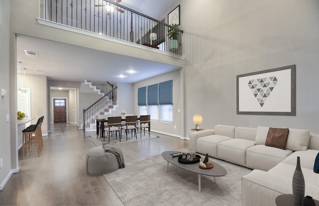 14577 Clementine Hall Dr, Conroe, TX 77378 - living room featuring stairway, wood finished floors, and a towering ceiling