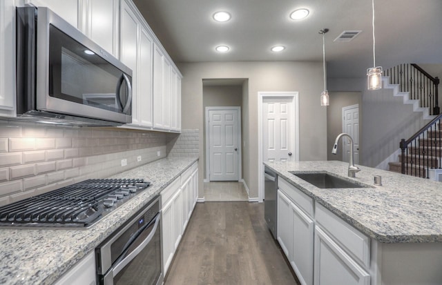14577 Clementine Hall Dr, Conroe, TX 77378 - kitchen featuring appliances with stainless steel finishes, backsplash, dark wood-style flooring, an island with sink, and recessed lighting