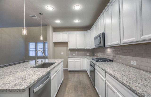 14577 Clementine Hall Dr, Conroe, TX 77378 - kitchen with stainless steel appliances, dark wood-style floors, white cabinets, backsplash, and recessed lighting