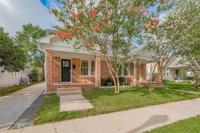 1026 W Cottage St, Houston, TX 77009 - view of front of home with brick siding, a porch, and a front yard