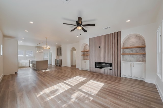 1026 W Cottage St, Houston, TX 77009 - unfurnished living room featuring a glass covered fireplace, ceiling fan, recessed lighting, light wood-type flooring, and arched walkways