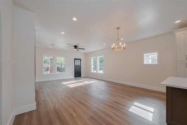 1026 W Cottage St, Houston, TX 77009 - unfurnished living room with recessed lighting, light wood-style floors, a chandelier, and a ceiling fan