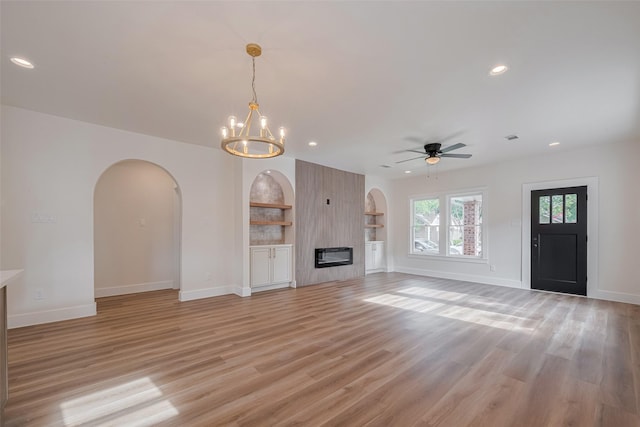 1026 W Cottage St, Houston, TX 77009 - unfurnished living room with arched walkways, recessed lighting, a ceiling fan, light wood-style flooring, and a large fireplace