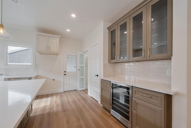 1026 W Cottage St, Houston, TX 77009 - indoor dry bar featuring wine cooler, decorative backsplash, light wood-style flooring, decorative light fixtures, and recessed lighting