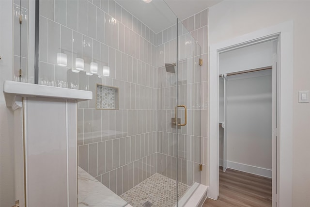 1026 W Cottage St, Houston, TX 77009 - full bathroom featuring a stall shower, wood finished floors, and a walk in closet