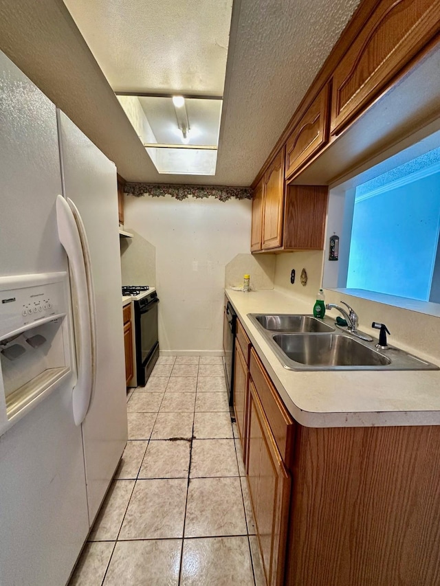 6206 Antha St, Houston, TX 77016 - kitchen featuring white refrigerator with ice dispenser, gas stove, a textured ceiling, light countertops, and light tile patterned floors