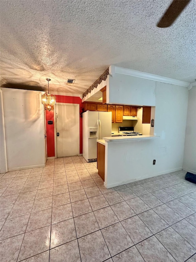 6206 Antha St, Houston, TX 77016 - kitchen with white fridge with ice dispenser, a peninsula, light countertops, a textured ceiling, and light tile patterned floors
