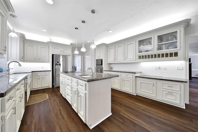 2206 Hickory Park Dr, Kingwood, TX 77345 - kitchen with stainless steel fridge with ice dispenser, a textured ceiling, dark wood-style floors, dark stone counters, and glass insert cabinets