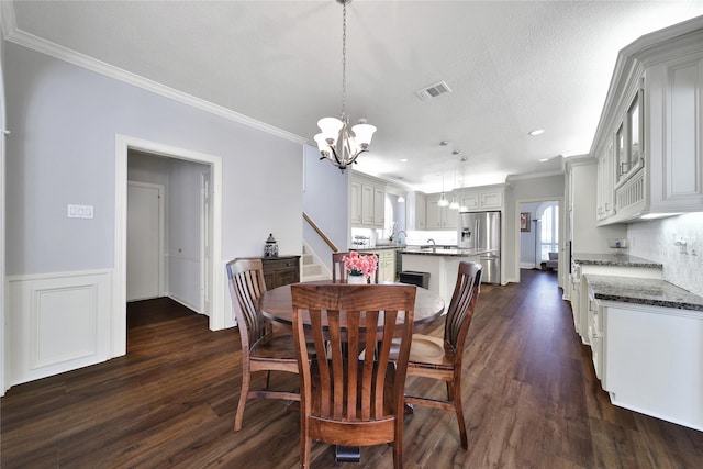2206 Hickory Park Dr, Kingwood, TX 77345 - dining area with a chandelier, dark wood finished floors, ornamental molding, recessed lighting, and wainscoting