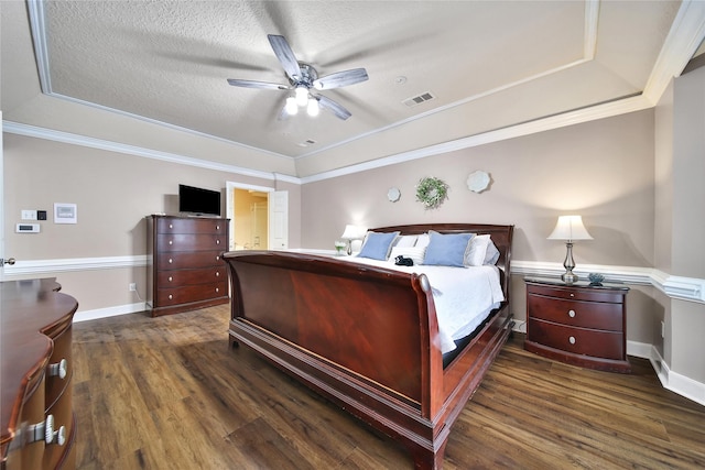 2206 Hickory Park Dr, Kingwood, TX 77345 - bedroom with a tray ceiling, dark wood-style flooring, ornamental molding, a ceiling fan, and connected bathroom