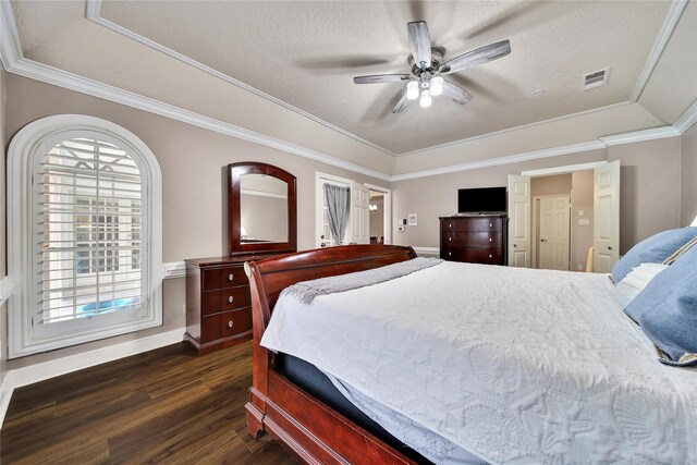 2206 Hickory Park Dr, Kingwood, TX 77345 - bedroom with dark wood-type flooring, a textured ceiling, ornamental molding, a ceiling fan, and a tray ceiling