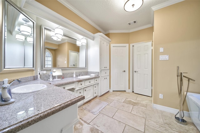 2206 Hickory Park Dr, Kingwood, TX 77345 - bathroom with double vanity, a textured ceiling, a tub, ornamental molding, and stone tile floors