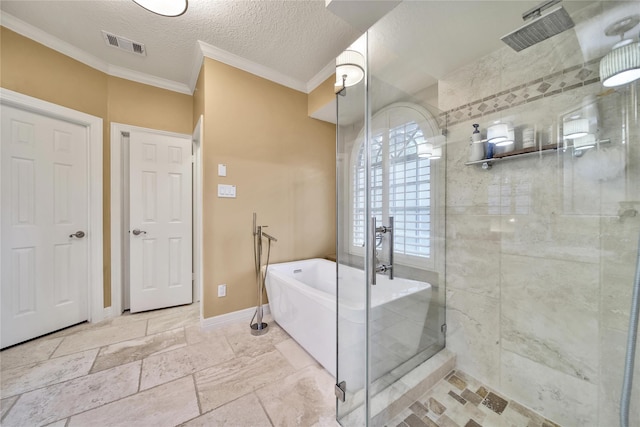 2206 Hickory Park Dr, Kingwood, TX 77345 - bathroom featuring a shower stall, ornamental molding, a freestanding tub, and a textured ceiling
