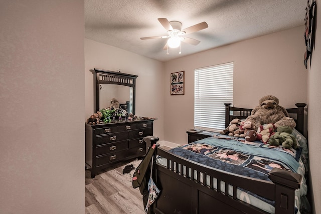 26752 Diamond Sq, Splendora, TX 77372 - bedroom featuring light wood-type flooring, a textured ceiling, and ceiling fan