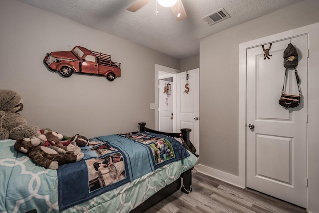 26752 Diamond Sq, Splendora, TX 77372 - bedroom featuring wood finished floors, a ceiling fan, and a textured ceiling