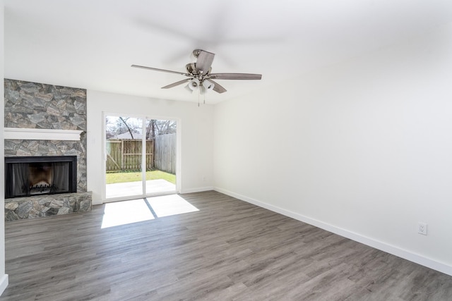 12239 Glenview Dr, Montgomery, TX 77356 - unfurnished living room featuring wood finished floors, ceiling fan, and a stone fireplace