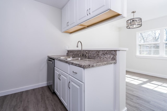12239 Glenview Dr, Montgomery, TX 77356 - kitchen with stainless steel dishwasher, wood finished floors, white cabinetry, and a chandelier