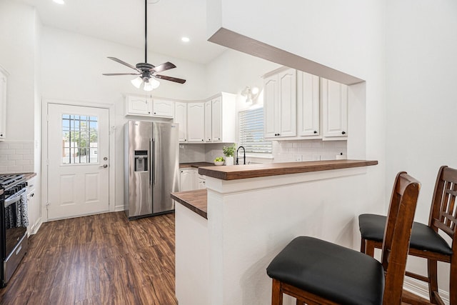 3515 Winnie St, Galveston, TX 77550 - kitchen featuring stainless steel appliances, wood counters, a kitchen breakfast bar, a peninsula, and healthy amount of natural light