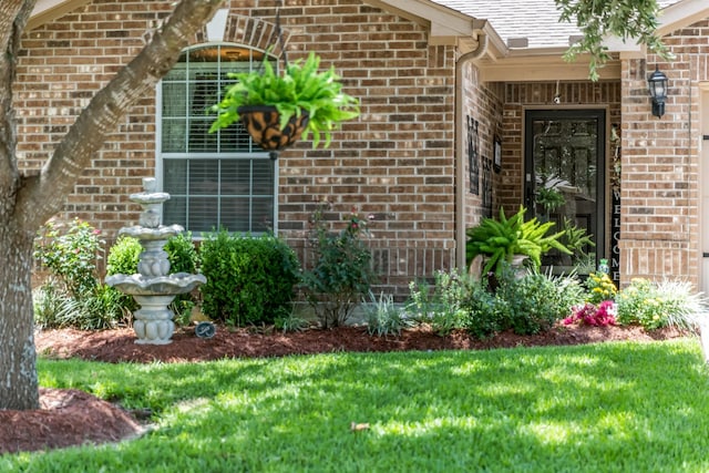 12114 Mabel Ln, Pinehurst, TX 77362 - doorway to property featuring brick siding, a yard, and a shingled roof