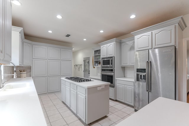 18988 Ocean Mist Ct, Montgomery, TX 77356 - kitchen with stainless steel appliances, light tile patterned flooring, light countertops, tasteful backsplash, and a kitchen island