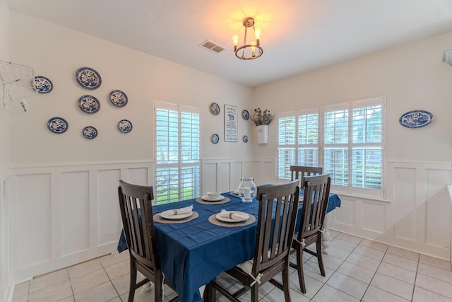 18988 Ocean Mist Ct, Montgomery, TX 77356 - dining area with a decorative wall, a chandelier, light tile patterned flooring, and wainscoting
