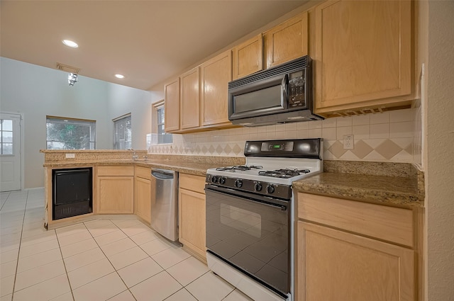 23035 Canal Rd, Richmond, TX 77406 - kitchen with black microwave, range, dishwasher, light brown cabinets, and light tile patterned floors