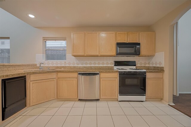 23035 Canal Rd, Richmond, TX 77406 - kitchen featuring black microwave, stainless steel dishwasher, range with gas cooktop, light brown cabinetry, and decorative backsplash