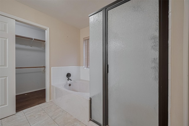 23035 Canal Rd, Richmond, TX 77406 - full bath featuring a shower stall, a garden tub, tile patterned floors, and a walk in closet