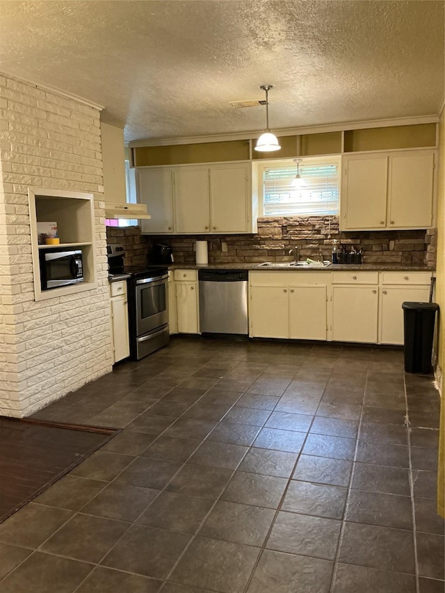 416 Fenn St, Houston, TX 77018 - kitchen featuring stainless steel appliances, backsplash, dark countertops, a textured ceiling, and crown molding