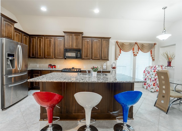 2627 Rosepoint Ct, Fresno, TX 77545 - kitchen with stainless steel fridge with ice dispenser, black microwave, tasteful backsplash, light stone counters, and vaulted ceiling