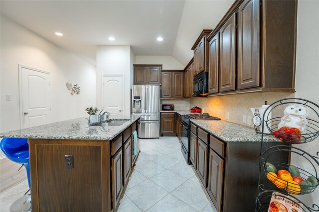2627 Rosepoint Ct, Fresno, TX 77545 - kitchen featuring black appliances, light stone counters, decorative backsplash, a kitchen bar, and vaulted ceiling