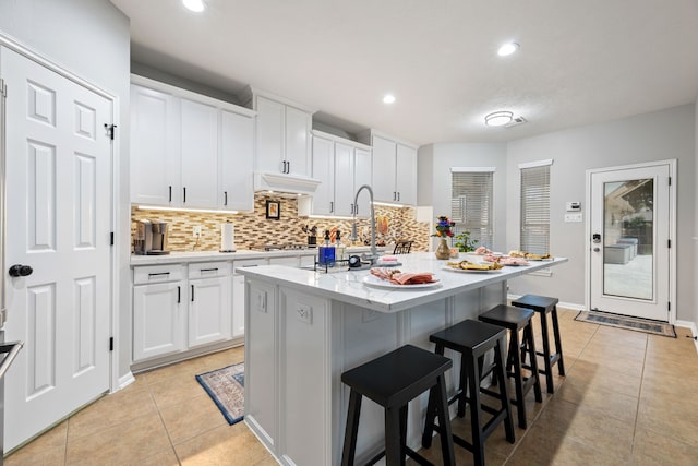 2006 Scarlet Trail Ct, Katy, TX 77494 - kitchen featuring tasteful backsplash, light tile patterned flooring, a breakfast bar, white cabinets, and recessed lighting
